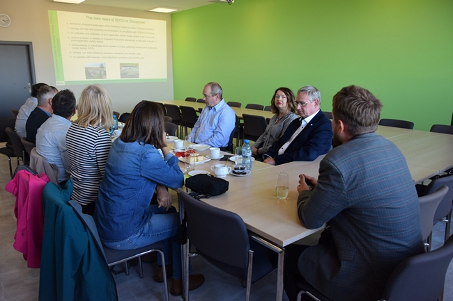 goście siedzący przy stole na sali konferencyjnej 