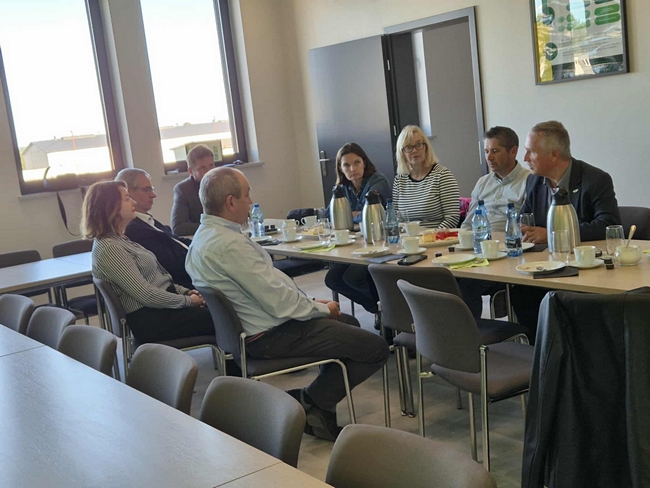 goście siedzący przy stole na sali konferencyjnej 