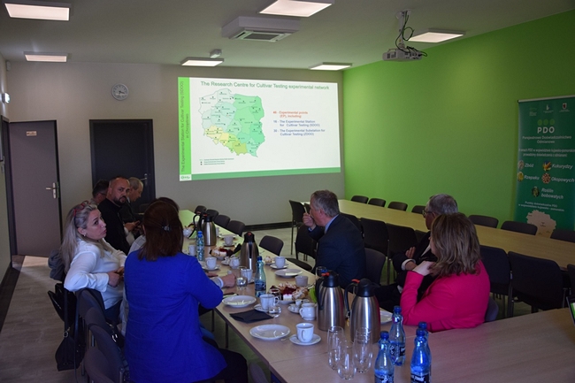 Uczestnicy spotkania siedzący przy stole na sali konferencyjnej 