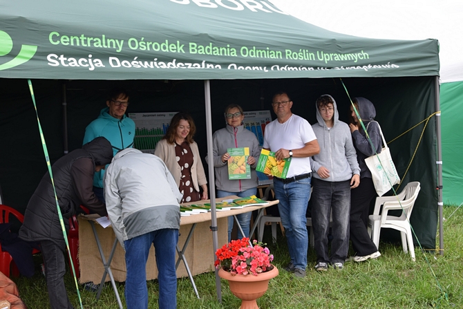 rolnicy odwiedzający stoisko stojący przed namiotem 