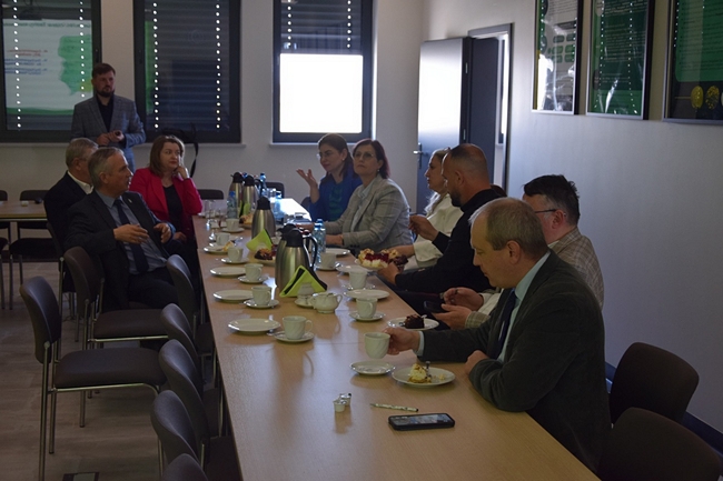 Uczestnicy spotkania siedzący przy stole na sali konferencyjnej 