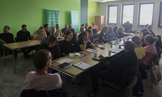 uczestnicy szkolenia siedzący przy stole na sali konferencyjnej