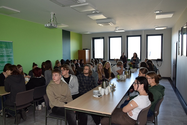 uczniowie siedzący na sali konferencyjnej